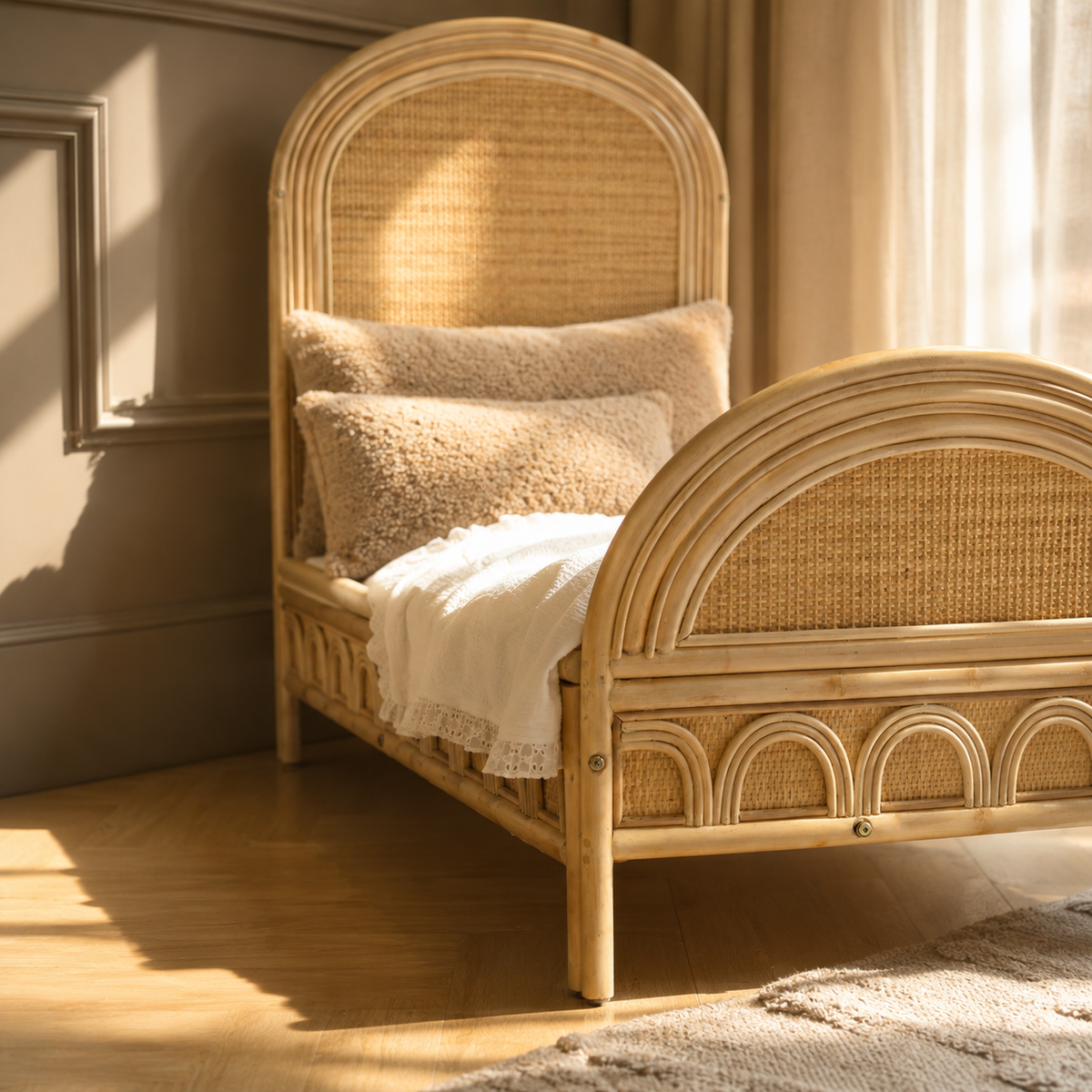 Naturel rotan kinderbed met handgevlochten hoofdbord en afgeronde afwerking in een warme kinderkamer