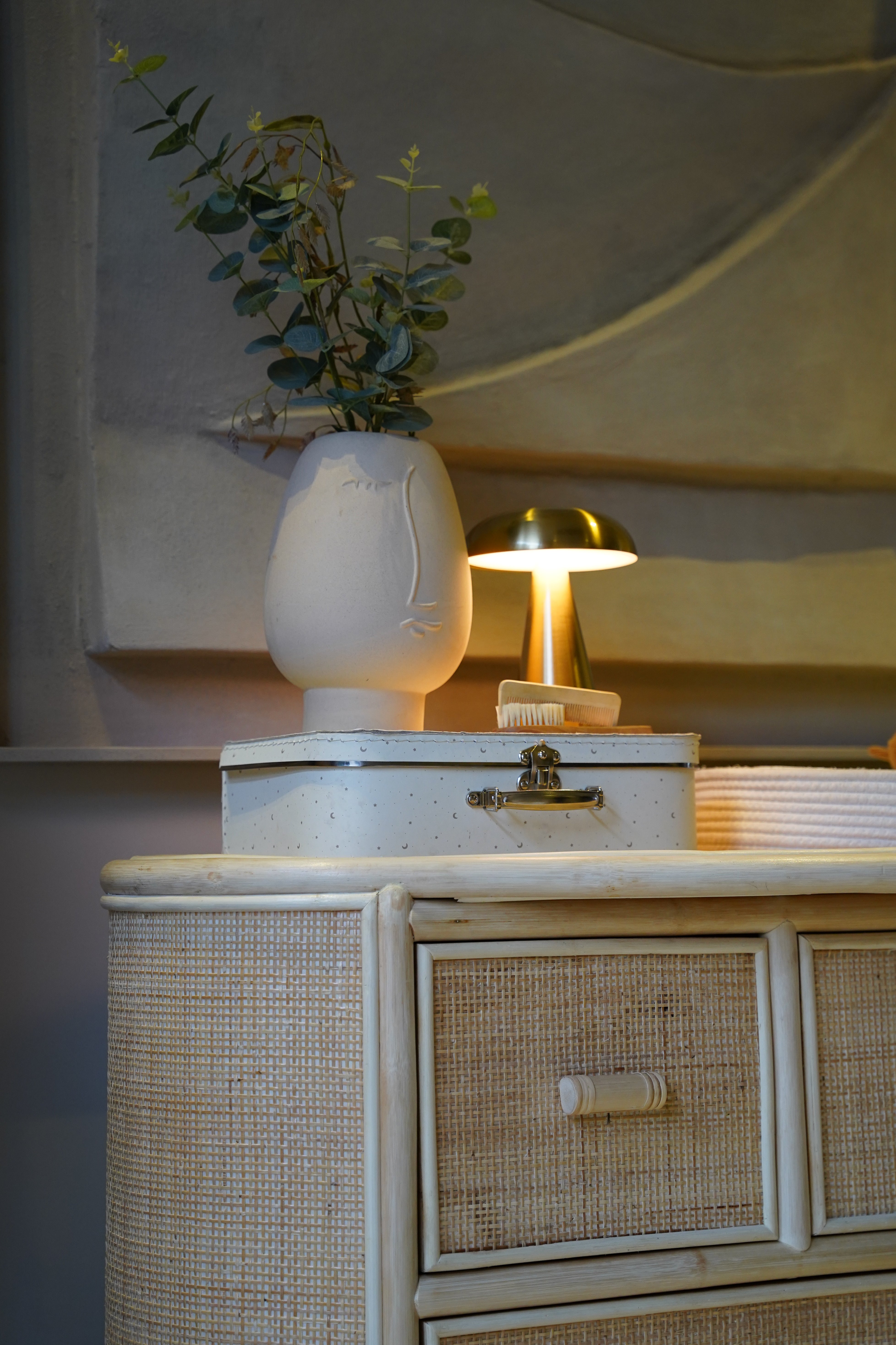 Detail van een naturel rotan commode met handgevlochten afwerking en afgeronde hoeken