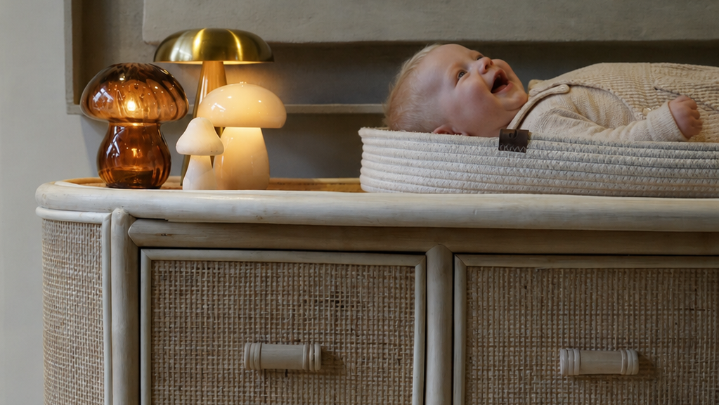 Naturel rotan commode met aankleedkussen en baby op een veilig verschoonoppervlak