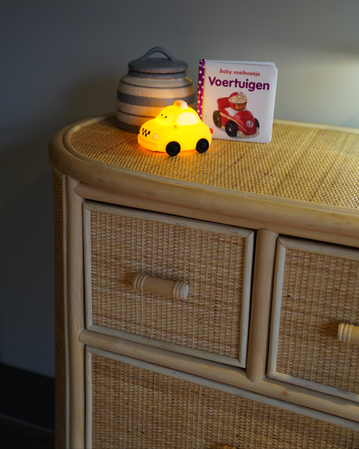 Detail van een naturel rotan commode met handgevlochten laden en afgerond bovenblad