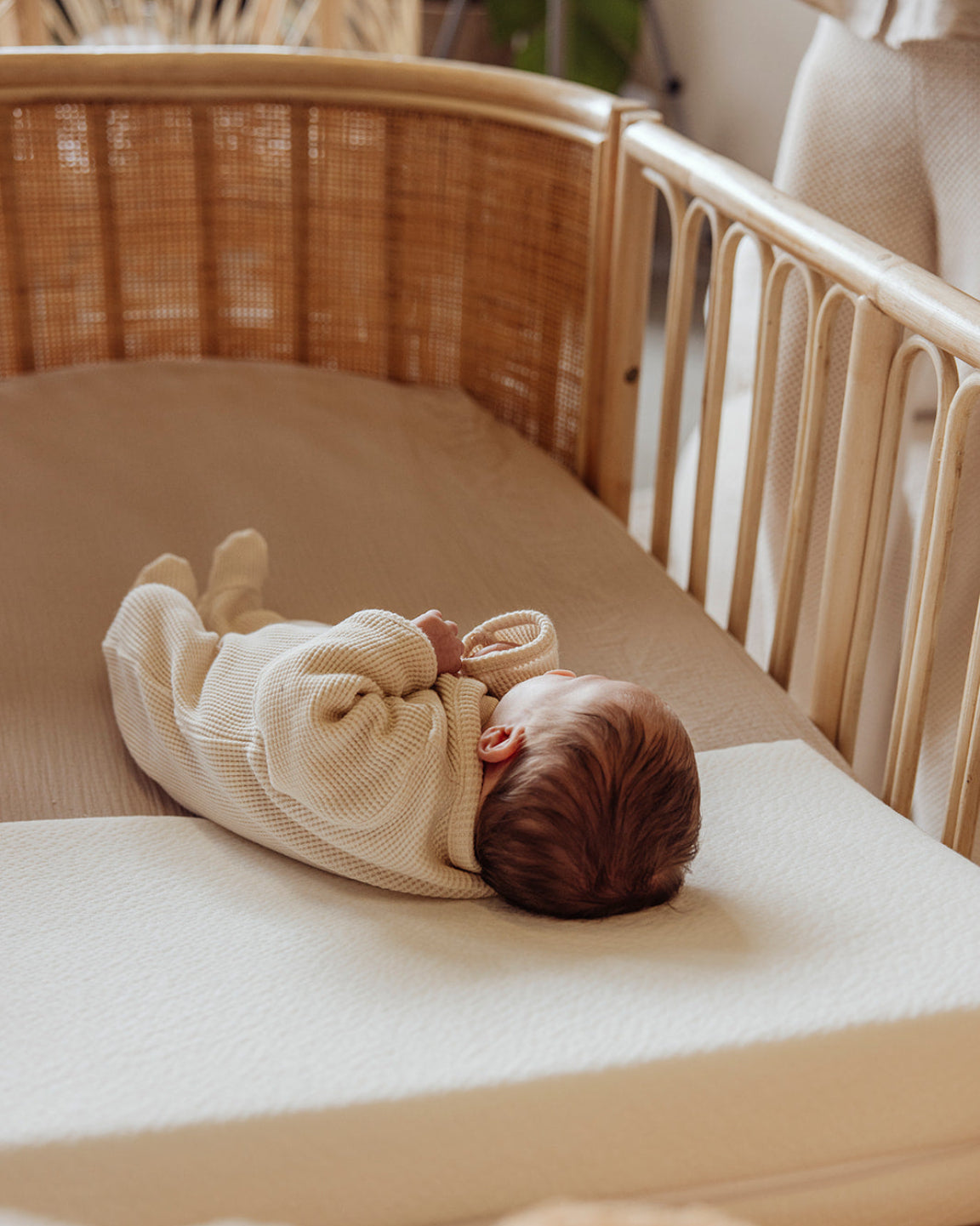 Baby slaapt in rotan meegroeibed Cosy