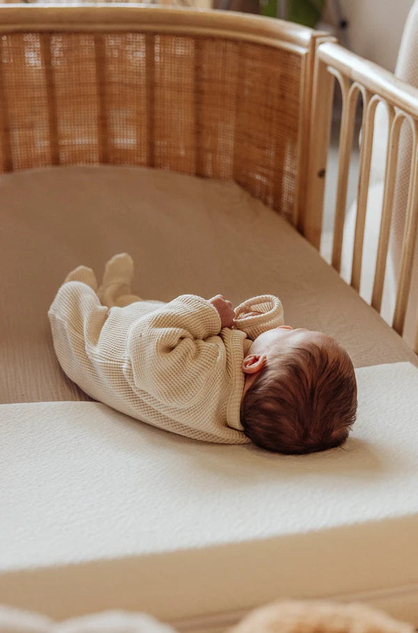 Baby slaapt in rotan meegroeibed Cosy