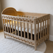Naturel rotan babybed met verstelbare bedbodem en handgevlochten details in een stijlvolle babykamer