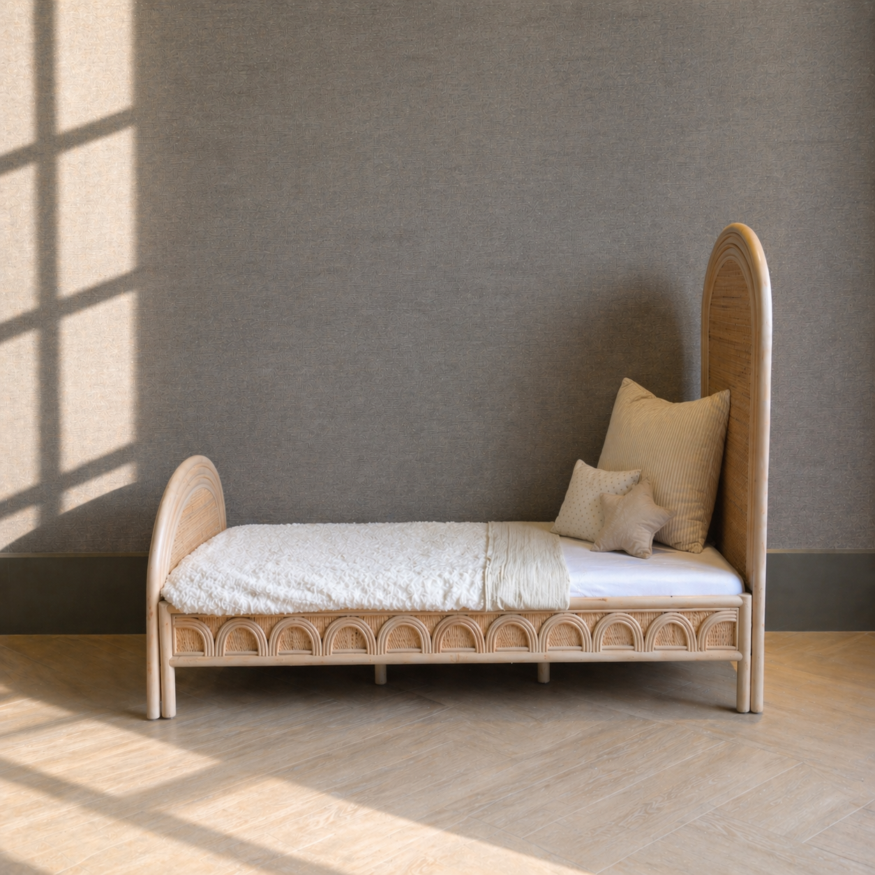 Naturel rotan kinderbed met hoog hoofdbord en handgevlochten zijpanelen voor een warme kinderkamer