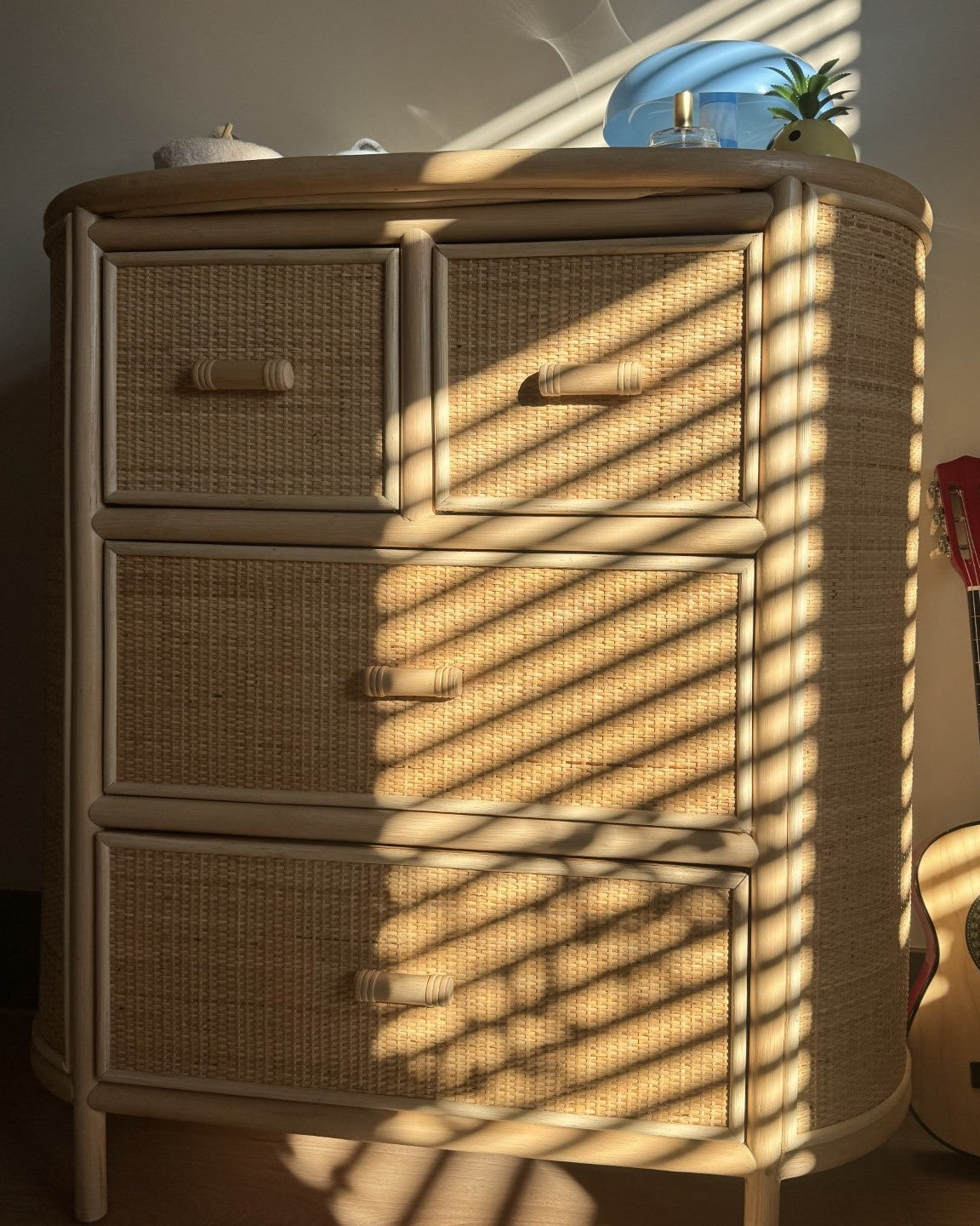 Naturel rotan commode met handgevlochten laden en afgeronde hoeken in warm natuurlijk licht
