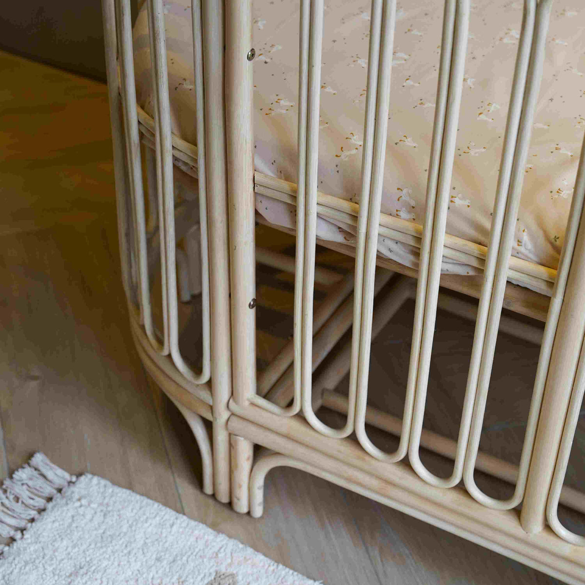Detail foto rotan ledikant sol met ronde rotan spijlen, transparant babybed