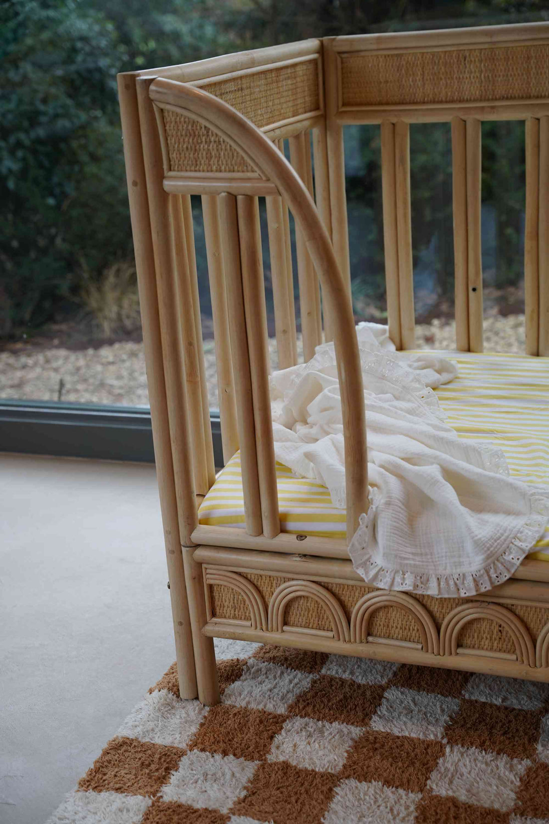 Detailfoto van het Rainbow 4-in-1 meegroeibed van natuurlijk rotan in peuteropstelling, met afgeronde instap, handgevlochten details en een veilige lage instap die zelfstandig in- en uitstappen stimuleert.